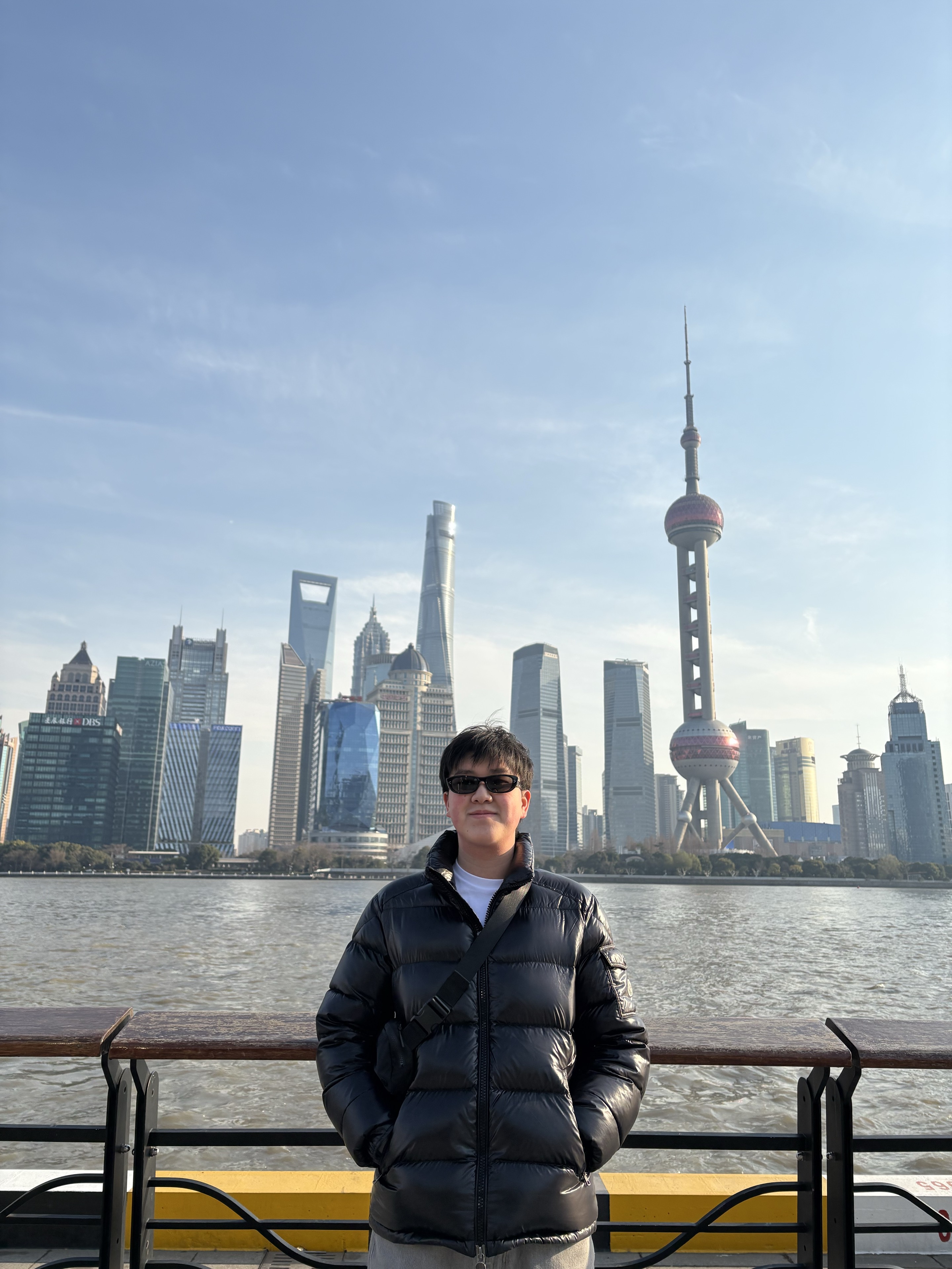 Evan Cao standing in front of the Shanghai skyline